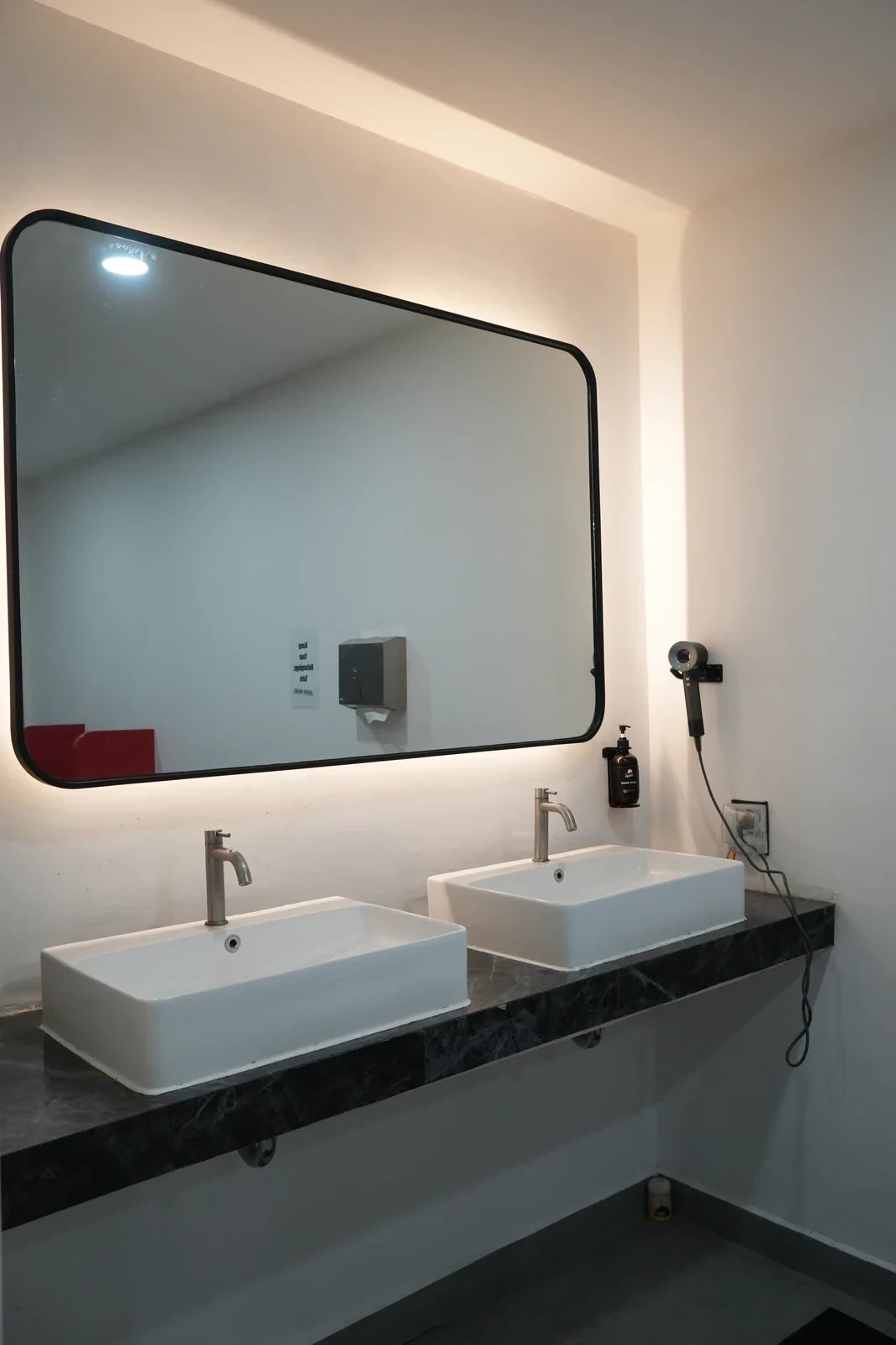 Modern bathroom with dual vanity sinks and large framed mirror