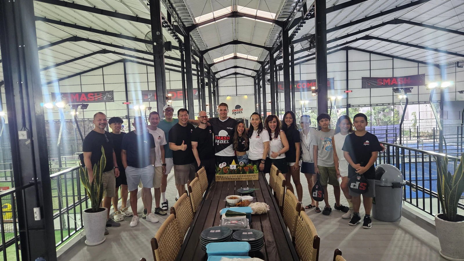 The professional Smash Padel team posing together at the facility